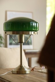 Aurelia 40cm Antiek messing/groen tafellamp Van Markslöjd - De antieke messingkleurige metalen voet is gecombineerd met een zacht gevormde kap van groen glas, wat de lamp een klassieke en stijlvolle uitstraling geeft.
