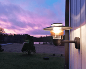 Arnäs Geoxideerd koper buitenlamp Van Westal - De wandlamp van Arná is een stijlvol armatuur met een rond lichtpatroon en een heldere glazen kap die de lichtbron omringt.