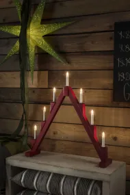 Candelabra 7 Lights ROOD Van Konstsmide - Opvouwbare elektrische kandelaar met 7 kaarsen, gemaakt van rood geverfd hout, versierd met messing ringen rond elke kaars voor een elegante toets.