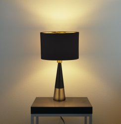 Chloe 40cm Matzwart tafellamp Van Searchlight - De ovale lampenkap met gouden binnenkant zorgt voor een warm en aangenaam licht, terwijl de slanke voet met contrasterende gouden voet een verfijnde toets toevoegt.