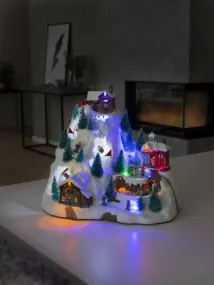 Mechanische Kerstdecoratie Met Berglandschap 28cm Veelkleurig Van Konstsmide - Het besneeuwde berglandschap licht op met prachtige LED-lampjes, bewegende details en speelt 8 klassieke kerstliedjes.