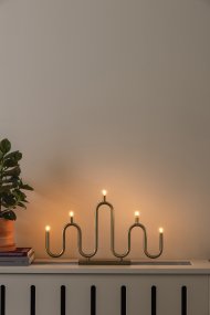 Noel 5 Messing Van Globen Lighting - Het zachte, golvende ontwerp is gemaakt van metalen buizen die met de hand op verschillende niveaus zijn gebogen en biedt een moderne interpretatie van de klassieke adventskaarsenhouder.
