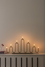 Noel 7 Messing Van Globen Lighting - Het zachte, golvende ontwerp is gemaakt van metalen buizen die met de hand op verschillende niveaus zijn gebogen en biedt een moderne interpretatie van de klassieke adventskaarsenhouder.