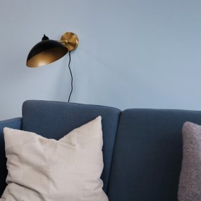 Futura 43cm Messing wandlamp Van Dyberg Larsen - Gemaakt van metaal met een zwarte buitenkant en een messing binnenkant, wat zorgt voor een elegante uitstraling.