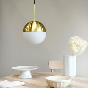 Nova Ø25 Messing Van Dyberg Larsen - De lamp heeft een ronde vorm met een koepel waarvan het bovenste deel is afgewerkt in messing en het onderste deel in opaalglas, wat zorgt voor een zacht en aangenaam licht.