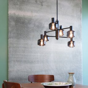Arp Ø50 Zwart hanglamp Van Dyberg Larsen - Creëer de perfecte balans tussen vorm en functie met de Arp-kroonluchter, die is voorzien van 6 prachtige glazen kappen van gerookt glas en een elegante zwarte ophanging.
