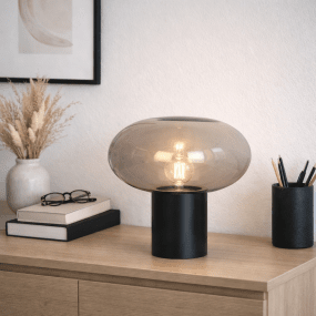 Alba 32cm Zwart/Rookkleurig tafellamp Van Nordic Lighting - De zwarte metalen voet zorgt voor een stabiele en elegante uitstraling, terwijl de kap van rookglas een zacht en sfeervol licht cre&euml;ert.