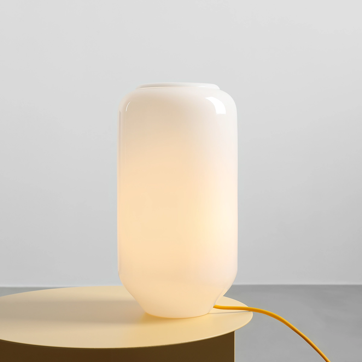 Flask 36cm Wit/geel tafellamp Van Artera - De hoge, ronde kap van opaalglas verspreidt een zacht en aangenaam licht dat een warme en uitnodigende sfeer creëert.