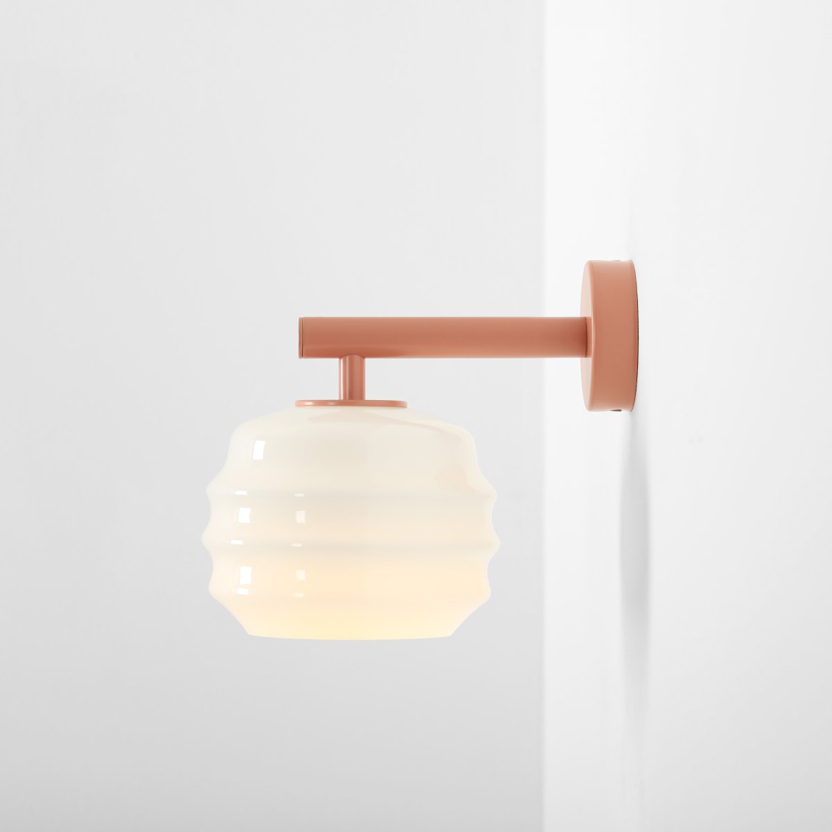 Puff 23cm Koraal wandlamp Van Artera - De koraalroze metalen details vormen een mooi contrast met het lichte glas en geven de lamp een warme uitstraling.