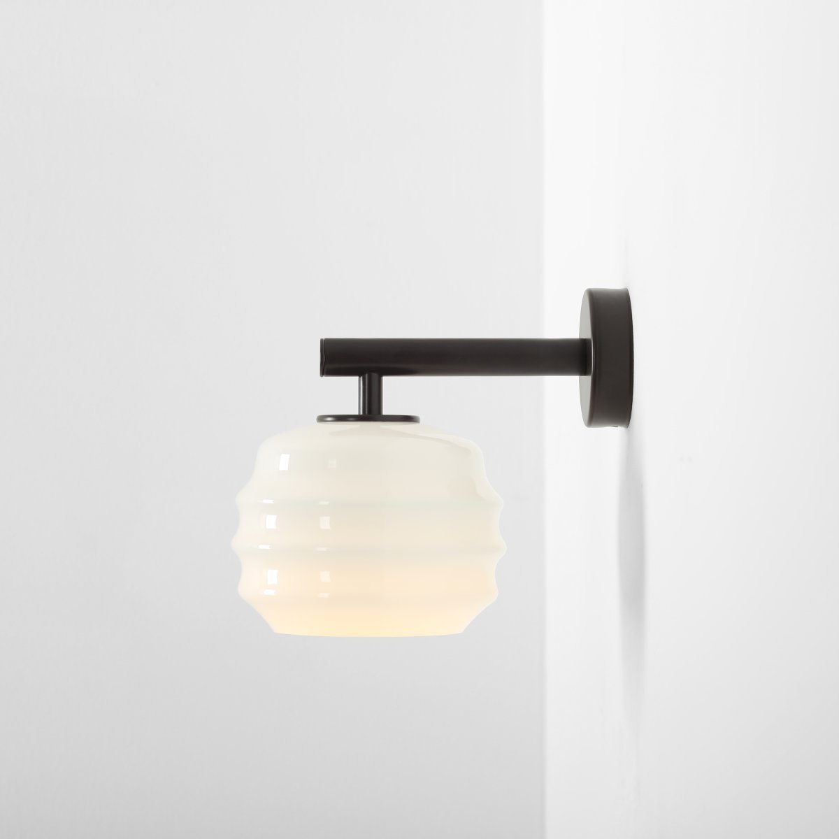 Puff 23cm Donkerbruin wandlamp Van Artera - De donkerbruine metalen details vormen een mooi contrast met het lichte glas en geven de lamp een warme uitstraling.