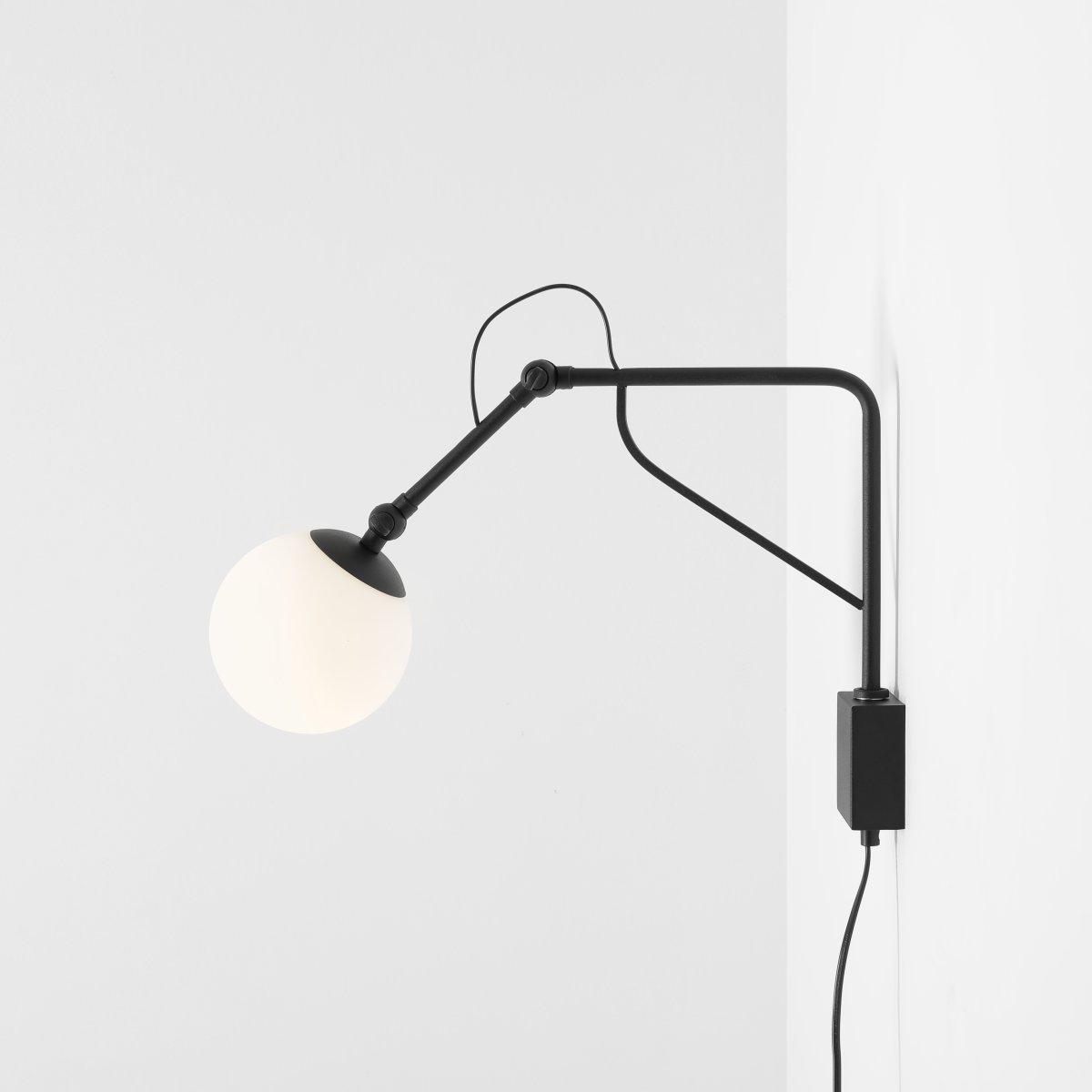 Soho 50cm Zwart wandlamp Van Artera - De lamp heeft een stijlvol matzwart metalen frame en een opaalbol die een zacht, warm licht verspreidt en een uitnodigende sfeer creëert in elke kamer.