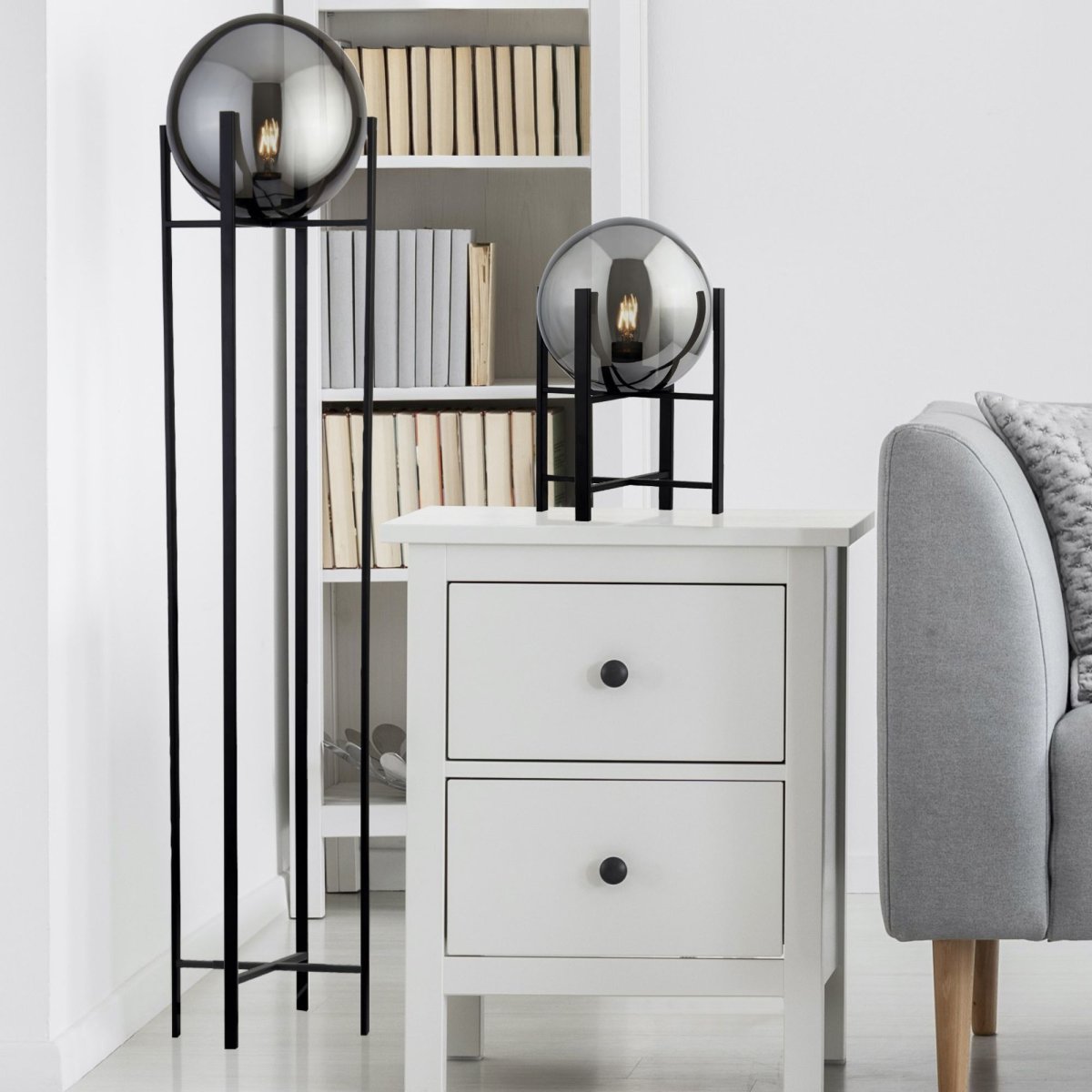 Amsterdam Zwart vloerlamp Van Searchlight - Met een gerookt ijshoorntje dat rust op; Een slank, zwart metalen frame creëert een stijlvol en mysterieus lichteffect dat perfect past in zowel moderne als industriële omgevingen.