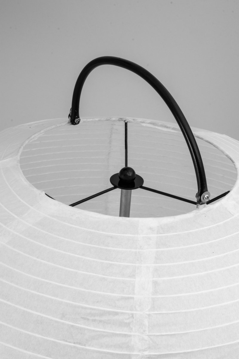 Osaka Wit vloerlamp Van Globen Lighting - De lamp is gemaakt van wit rijstpapier en heeft een decoratief handvat van matzwart gelakt metaal en een bijpassende standaard aan de onderkant waarop de papieren kap rust.