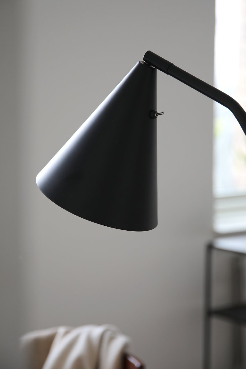 Funil Zwart vloerlamp Van Markslöjd - De lamp is gemaakt van zwart gelakt metaal en heeft een decoratieve, kegelvormige lampenkop die draaibaar en verstelbaar is.