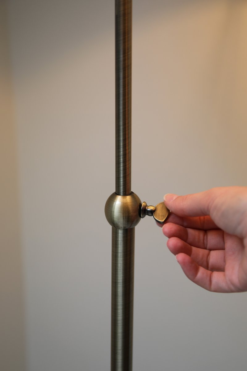 Oxford Antiek messing vloerlamp Van Markslöjd - Staande lamp in klassieke stijl van rond de eeuwwisseling met een gebroken witte stoffen kap en een voet met een antiek messing afwerking.