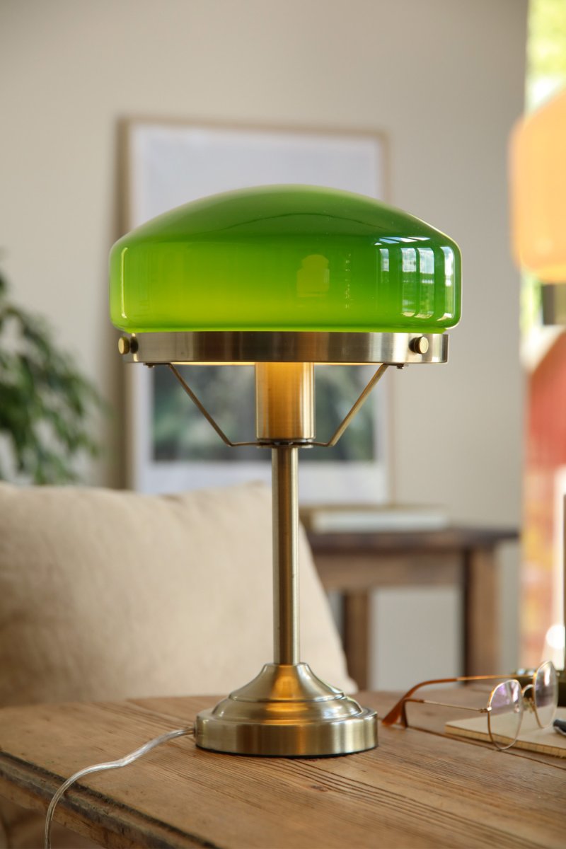 Aurelia 40cm Antiek messing/groen tafellamp Van Markslöjd - De antieke messingkleurige metalen voet is gecombineerd met een zacht gevormde kap van groen glas, wat de lamp een klassieke en stijlvolle uitstraling geeft.