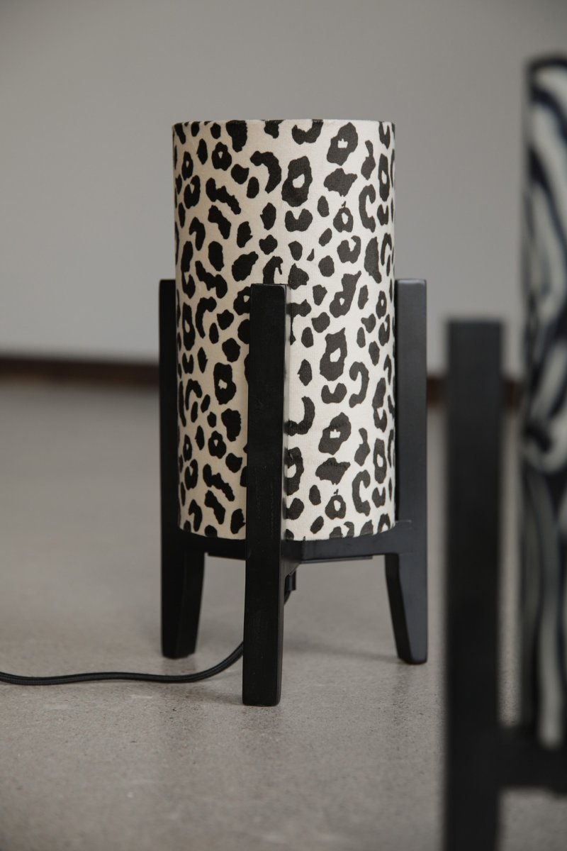 Eruca 34cm Luipaard tafellamp Van Markslöjd - De lampvoet van zwart hout is gecombineerd met een cilindrische textielen kap in gebroken wit en bruin luipaardpatroon, wat de lamp een trendy en persoonlijk karakter geeft.