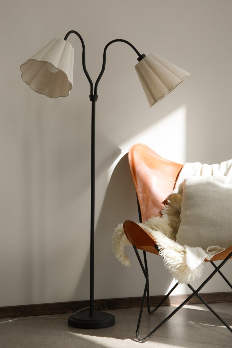 Veya 2 Zwart vloerlamp Van Markslöjd - Veya is een stijlvolle vloerlamp met een zwarte metalen voet en twee beige textielen kappen die een zacht contrast cre&euml;ren.
