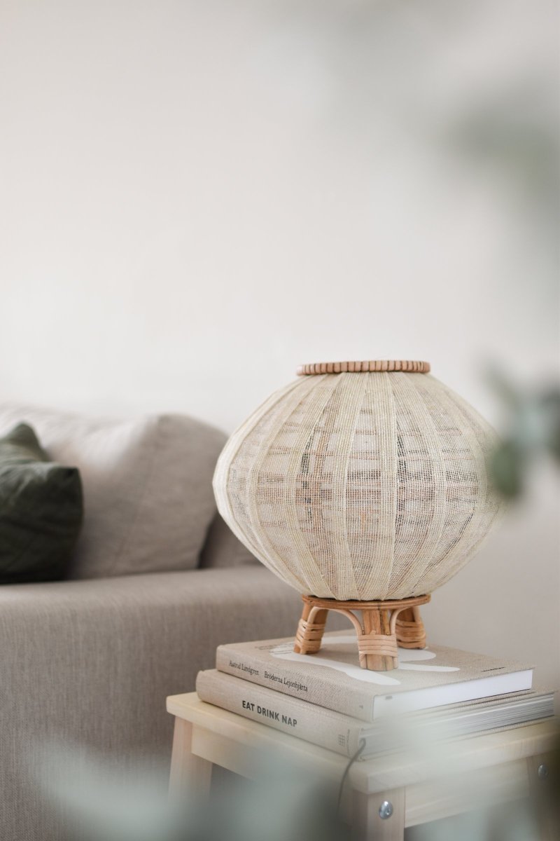 Borneo 37cm Natuur tafellamp Van Globen Lighting - De lamp is gemaakt van naturelkleurig rotan en gebroken wit linnen en heeft een 200 cm lang wit textielsnoer met schakelaar en stekker.