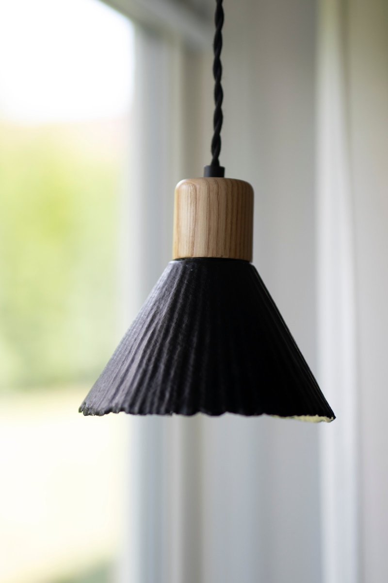 Linnea Ø16 Zwart hanglamp Van Globen Lighting - Het papier is gerecycled en ongebleekt en de bovenkant is zwart gelakt, wat een spannend contrast cre&euml;ert met de naturelkleurige houten lampenhouder.