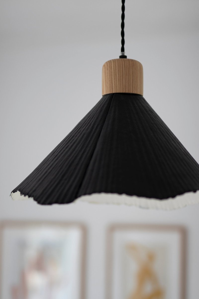 Linnea Ø40 Zwart hanglamp Van Globen Lighting - Het papier is gerecycled en ongebleekt en de bovenkant is zwart gelakt, wat een spannend contrast cre&euml;ert met de naturelkleurige houten lampenhouder.