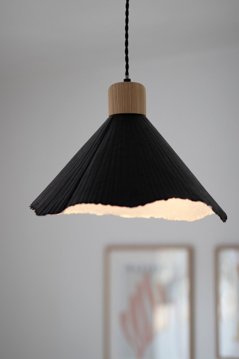 Linnea Ø40 Zwart hanglamp Van Globen Lighting - Het papier is gerecycled en ongebleekt en de bovenkant is zwart gelakt, wat een spannend contrast cre&euml;ert met de naturelkleurige houten lampenhouder.