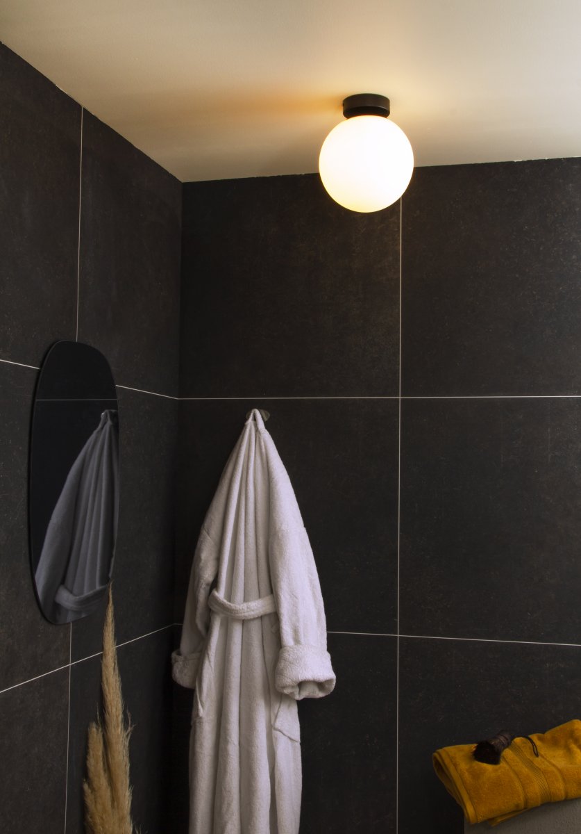 Lido Ø20 Zwart badkamerlamp Van Aneta Lighting - Het matzwarte metalen frame is gecombineerd met een ronde kap van opaalglas die een zacht en aangenaam licht verspreidt.