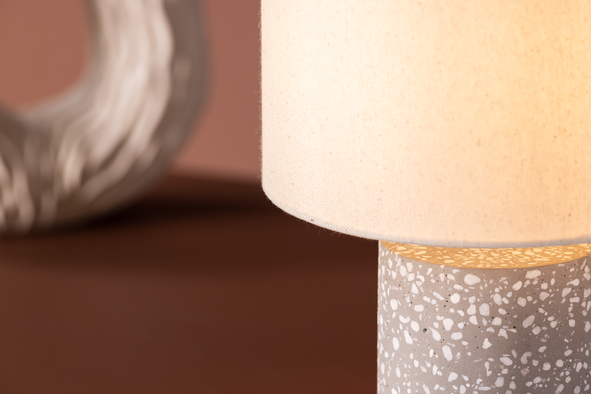 Dijon 35cm Grijs tafellamp Van Venture Design - De lamp heeft een voet in prachtig grijs terrazzo met witte accenten en een lampenkap in fijn beige linnen.