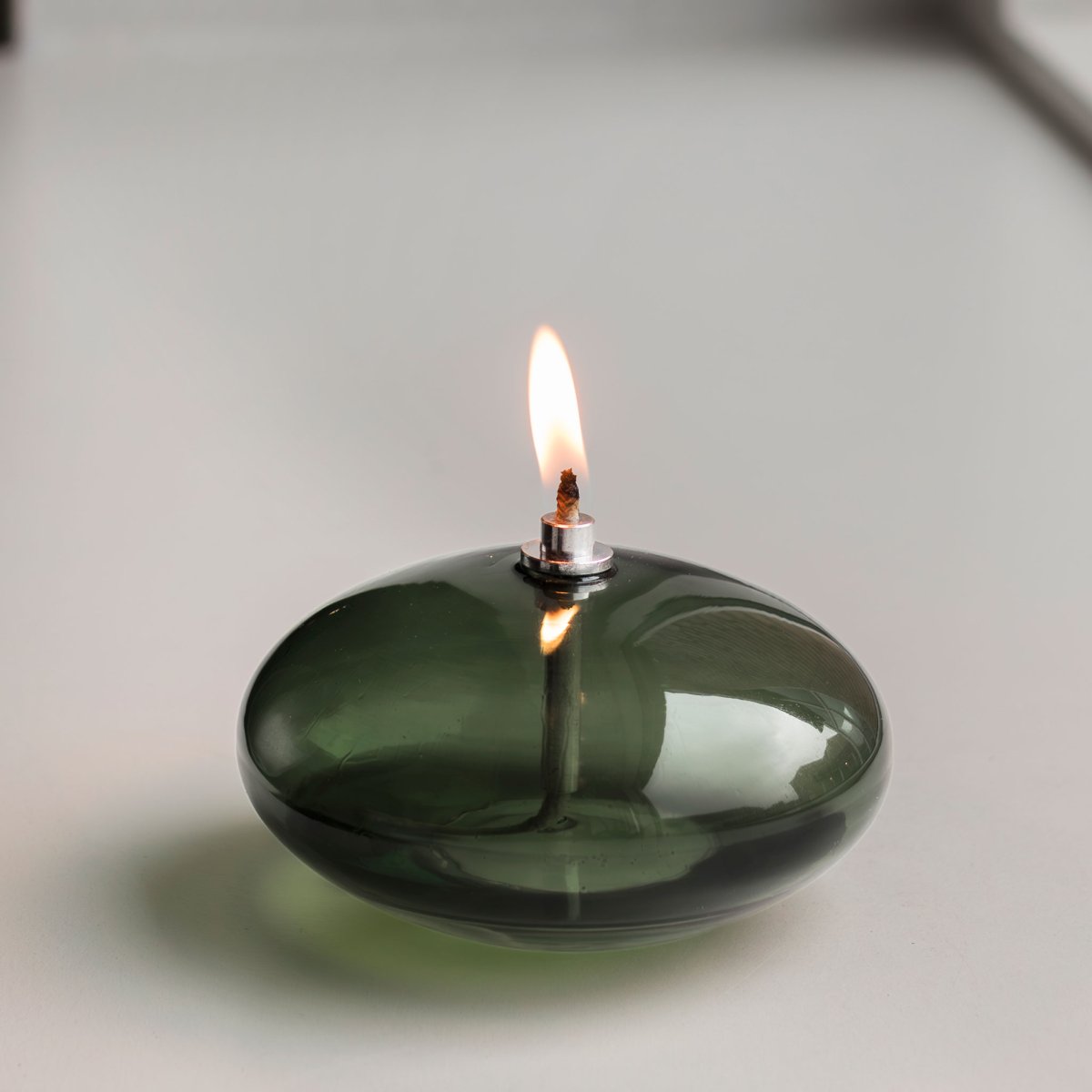 Olie Lamp Aura Klein Donkergroen Van Mette Ditmer - Den djupgr&ouml;na f&auml;rgen ger en st&auml;mningsfull k&auml;nsla, och n&auml;r l&aring;gan t&auml;nds sprider lampan ett mjukt, varmt ljus som skapar en avkopplande atmosf&auml;r.