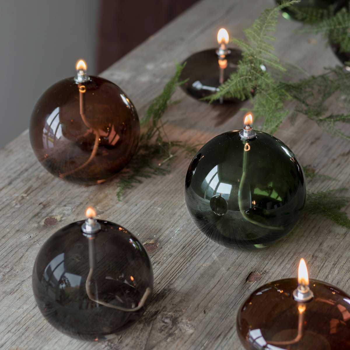 Olie Lamp Aura Groot Rookkleurig Van Mette Ditmer - Dess eleganta design och r&ouml;kf&auml;rgade glas sprider ett mjukt, varmt ljus som ger en lugn och mysig k&auml;nsla.