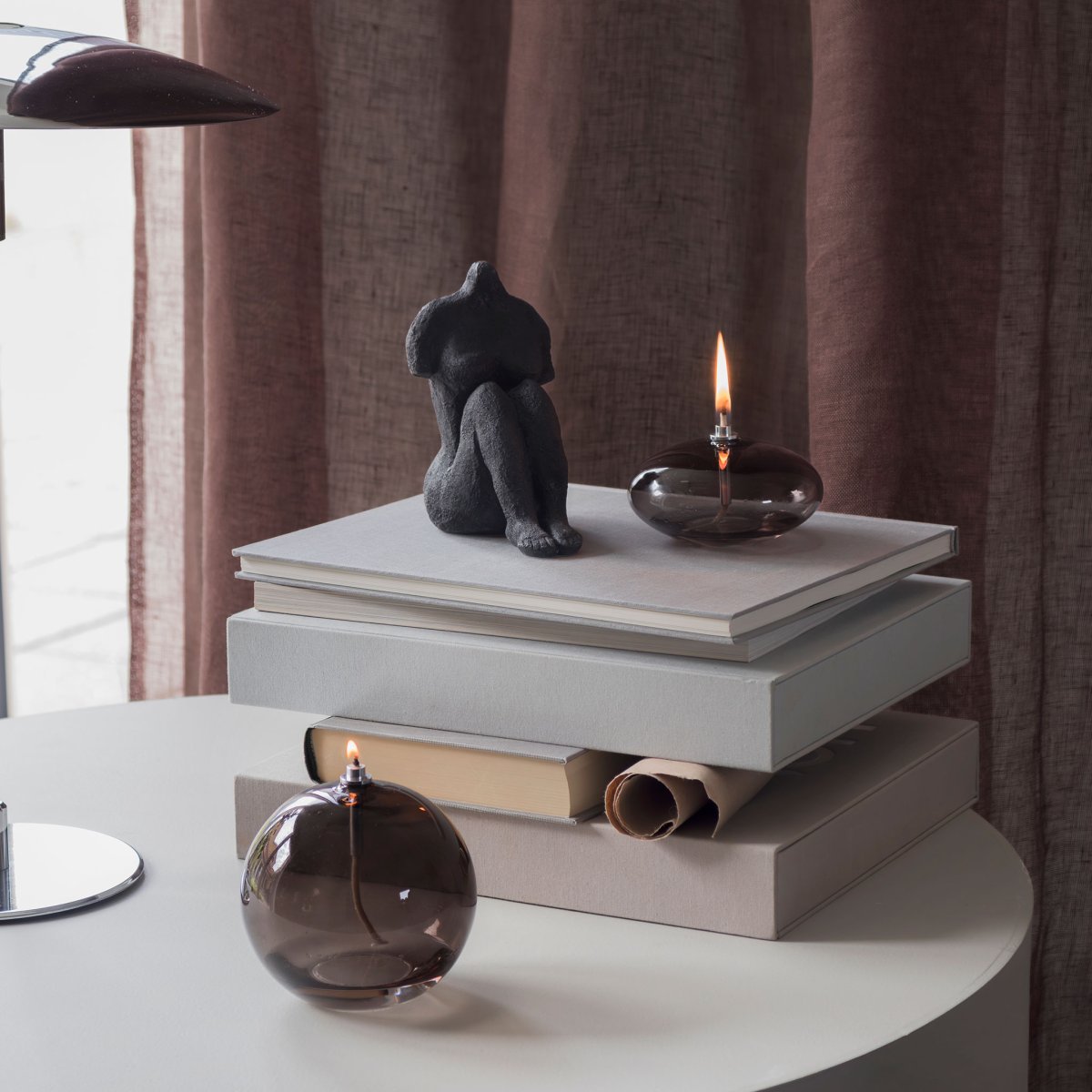 Olie Lamp Aura Groot Rookkleurig Van Mette Ditmer - Dess eleganta design och r&ouml;kf&auml;rgade glas sprider ett mjukt, varmt ljus som ger en lugn och mysig k&auml;nsla.