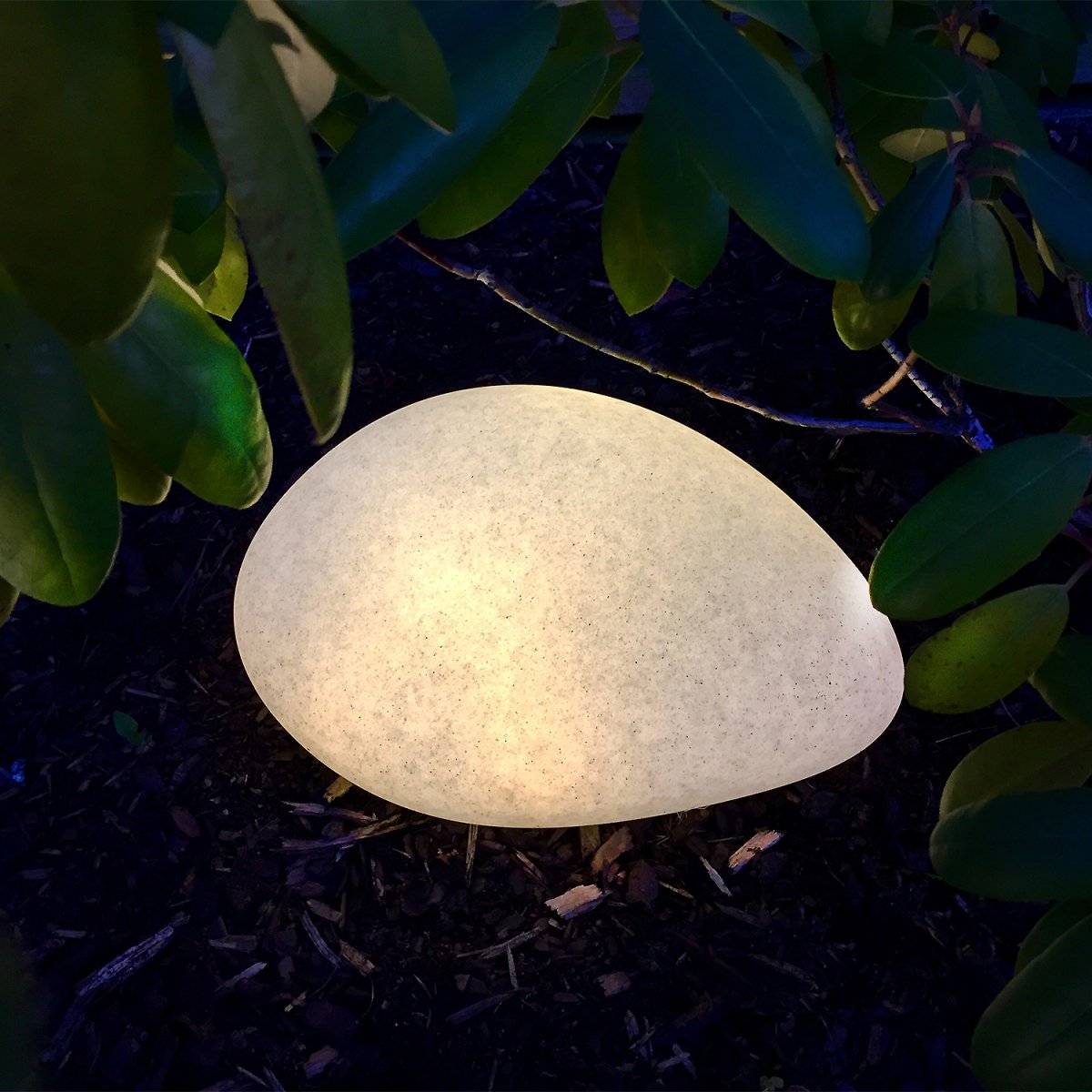 Stone XL Grijs Van Lightson - Het licht dringt door het groen van de planten heen en zorgt voor een gezellige gloed die de structuur van uw tuin versterkt.