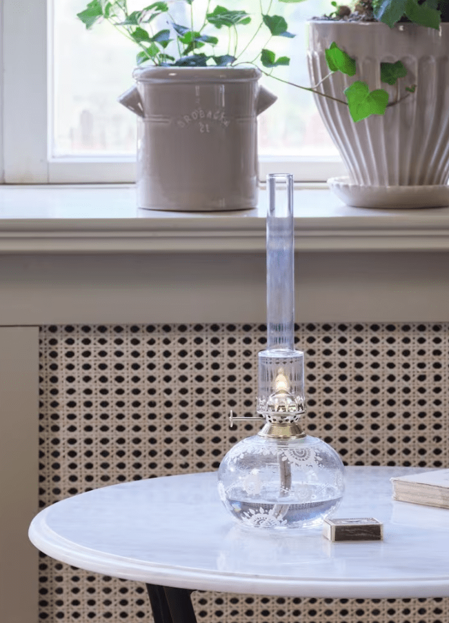 Kerosene lamp Oval Marja Transparant Van Strömshaga - Een prachtige ronde petroleumlamp van helder glas met prachtige witte handgemaakte bloemen, een messing brander en een branderbuis van helder glas.