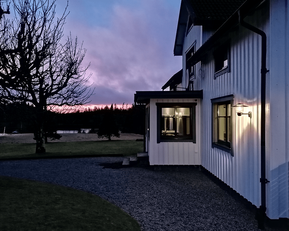 Arnäs Gegalvaniseerd staal buitenlamp Van Westal - De wandlamp van Arn&aacute; is een stijlvol armatuur met een rond lichtpatroon en een heldere glazen kap die de lichtbron omringt.