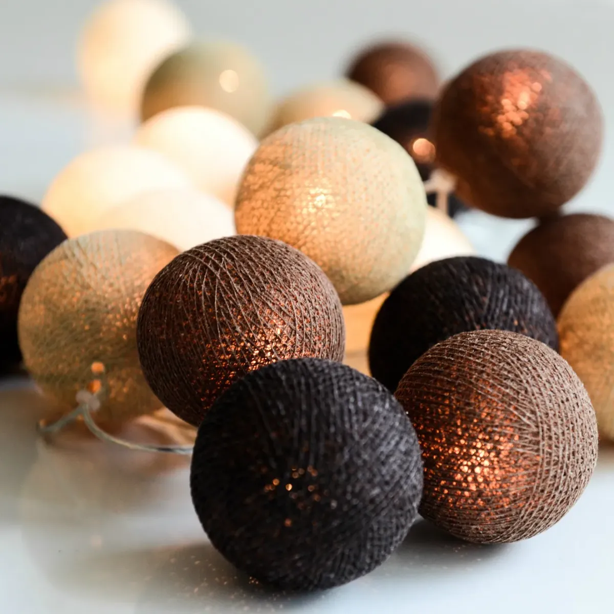 Irislights Brownie 20-lights Bruin Van Irislights - De lichtslinger wordt geleverd met handgemaakte bollen van katoen en polyester in verschillende bruintinten die een mooie gloed verspreiden wanneer ze branden.