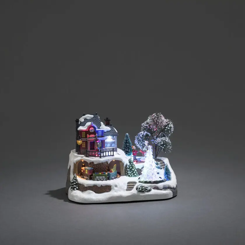 Mechanische Kerstdecoratie Met Treinstation 17cm Veelkleurig Van Konstsmide - Stap in een winterse miniatuurwereld met deze mechanische kerstversiering &ndash; een charmant treinstation in een besneeuwde omgeving.