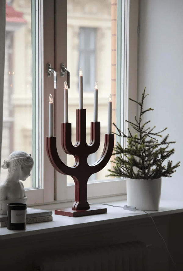 Sapin 5L ROOD Van Markslöjd - Dankzij het royale formaat is het een decoratieve blikvanger, vooral in grote ramen waar de vijf kaarsen een warme en sfeervolle gloed verspreiden tijdens donkere winteravonden.