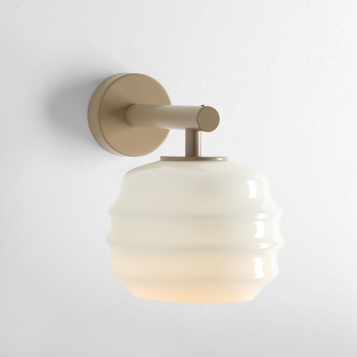 Puff 23cm Beige wandlamp Van Artera - De beige metalen details vormen een mooi contrast met het lichte glas en geven de lamp een warme uitstraling.