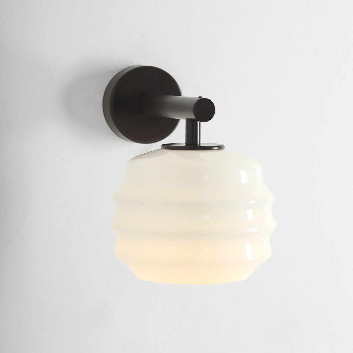 Puff 23cm Donkerbruin wandlamp Van Artera - De donkerbruine metalen details vormen een mooi contrast met het lichte glas en geven de lamp een warme uitstraling.