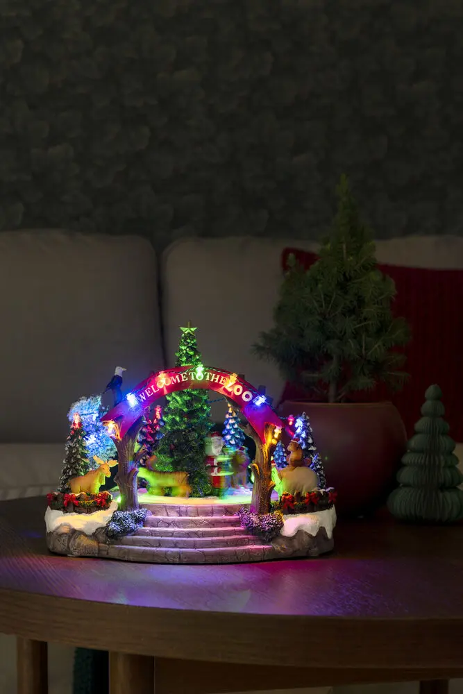 Mechanische Kerstdecoratie Met Dierentuin 20cm Veelkleurig Van Konstsmide - Deze mechanische kerstversiering biedt een kleurrijk tafereel met 19 warmwitte LED-lampjes, muziek, dieren en de Kerstman rond een fonkelende kerstboom.