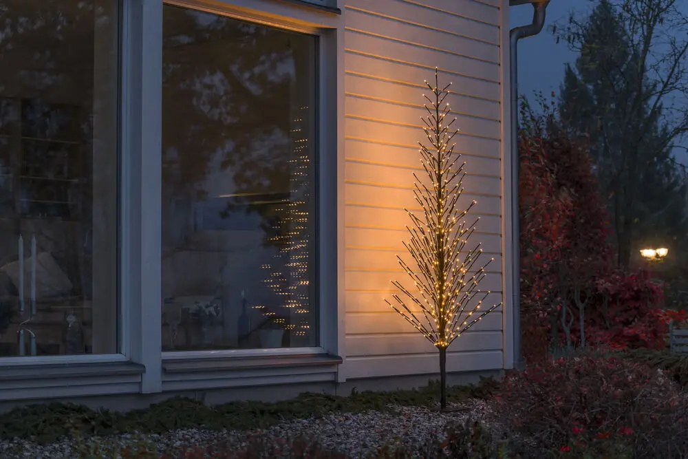 Zwart Hout 210cm Zwart Van Konstsmide - Een elegante, zwarte decoratieve boom die de winter verlicht met 504 warme, amberkleurige LED-lampjes met een vast en vuurvliegeffect.