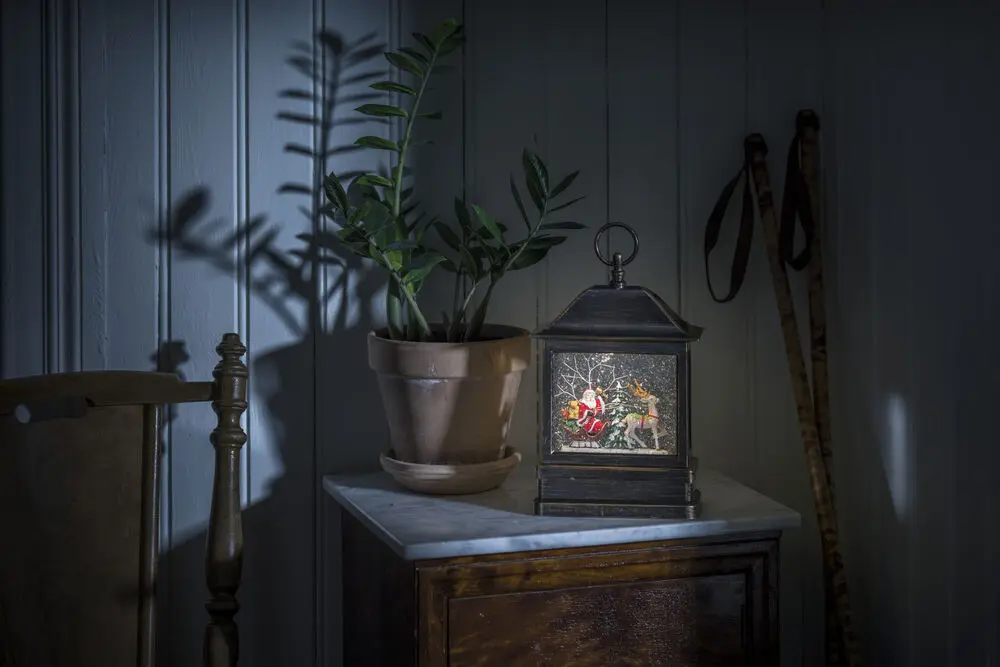 Met Water Gevulde Lantaarn Met Kerstman In Slee Bruin Van Konstsmide - Met een prachtig tafereel van de Kerstman en zijn rendieren in een winterlandschap, glinsterende sneeuw&ouml; en warmwit LED-licht (3000K) vormt het een sfeervol detail in huis.