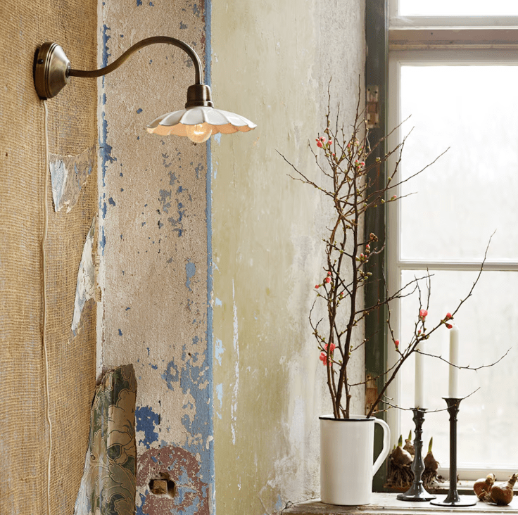 Gustav Ø20 Wit/antiek messing wandlamp Van Strömshaga - De antieke messing afwerking is gecombineerd met een wit gelakte metalen kap met een prachtig golvende rand, wat een zachte en stijlvolle uitstraling geeft.