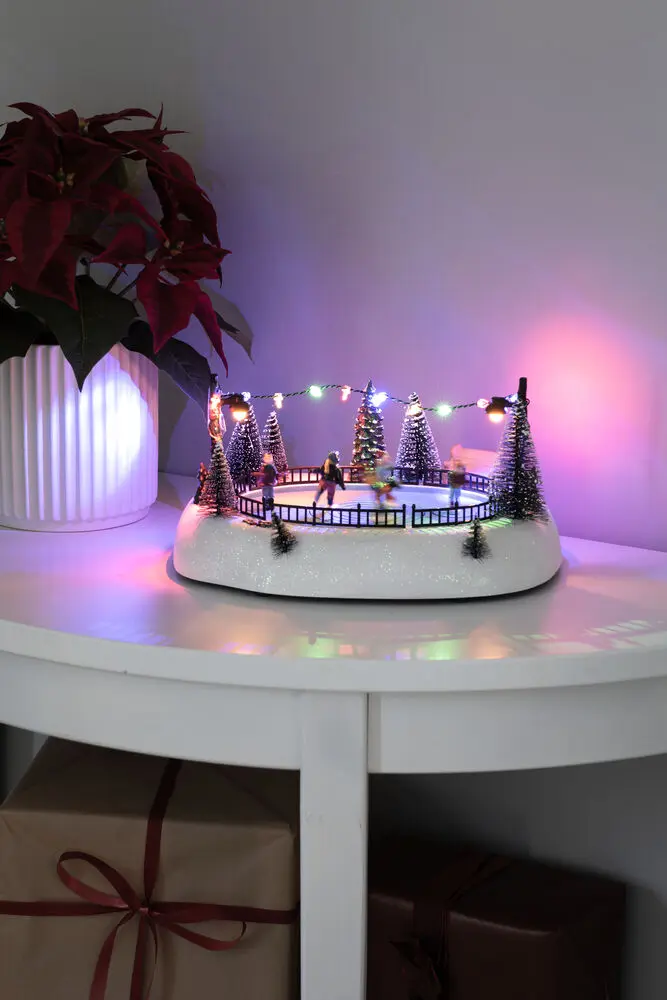 Mechanische Kerstdecoratie Met Schaatsbaan 13cm Veelkleurig Van Konstsmide - Cre&euml;er beweging en vreugde in uw kerstdorp met dennenbomen, lichtsnoeren en een winters landschap.