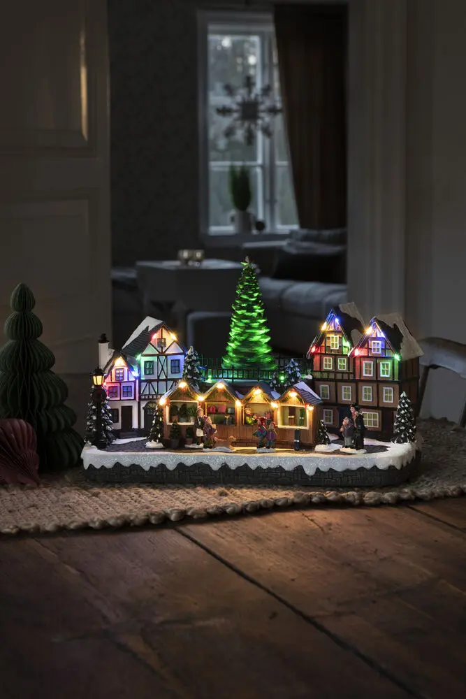 Mechanische Kerstdecoratie Met Kerstmarkt 24cm Veelkleurig Van Konstsmide - Met 28 warmwitte LED-lampjes, met sneeuw bedekte huizen, kleurrijke marktkraampjes en een statige kerstboom in het midden verspreidt het zowel licht als muziek.