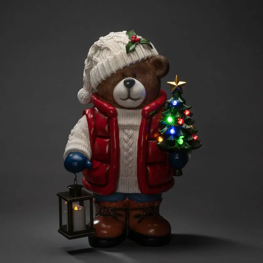 Grote Teddybeer 66cm Veelkleurig Van Konstsmide - Er staat een felverlichte kerstboom en een lantaarn in, wat voor een gezellige sfeer zorgt.
