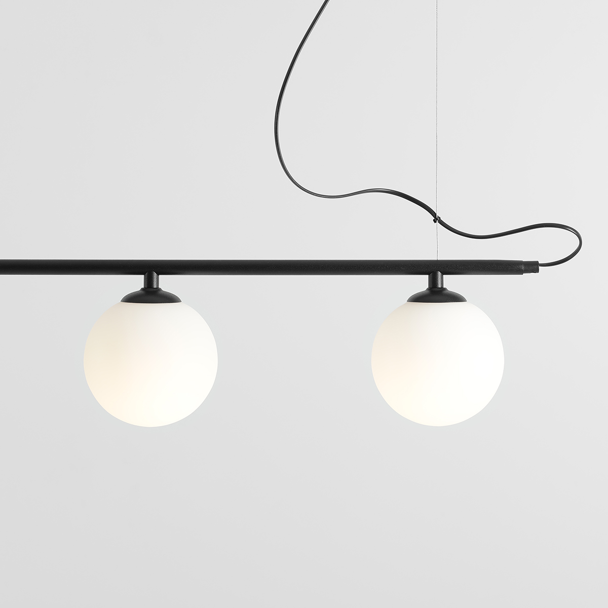 Beryl 140cm Zwart hanglamp Van Artera - De minimalistische zwarte staaf vormt een elegant contrast met de witte bollen en geeft de lamp een moderne en verfijnde uitstraling.