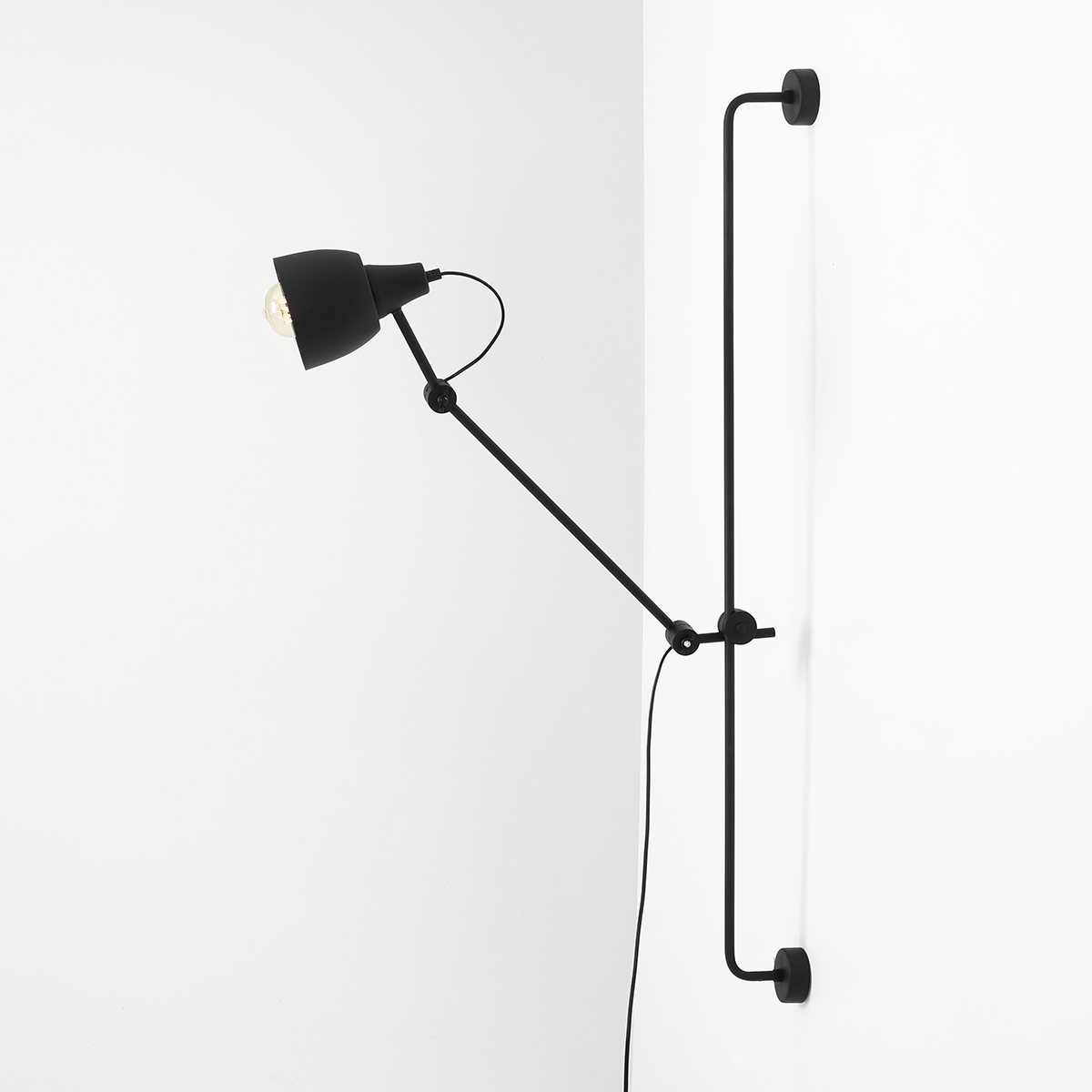 Dron 113cm Zwart wandlamp Van Artera - De matte zwarte afwerking geeft de lamp een industriële en verfijnde uitstraling, terwijl de verstelbare arm maximale flexibiliteit biedt om het licht te richten waar u het nodig hebt.