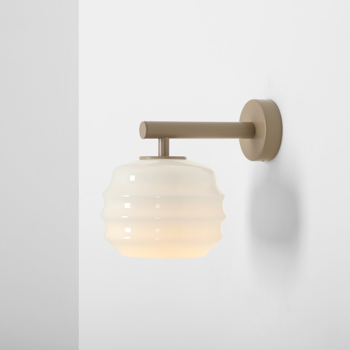 Puff 23cm Beige wandlamp Van Artera - De beige metalen details vormen een mooi contrast met het lichte glas en geven de lamp een warme uitstraling.