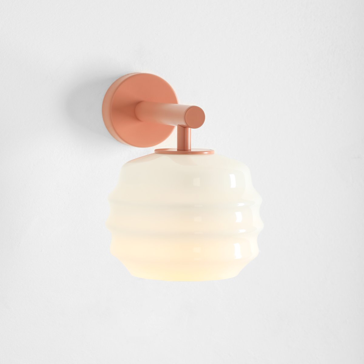 Puff 23cm Koraal wandlamp Van Artera - De koraalroze metalen details vormen een mooi contrast met het lichte glas en geven de lamp een warme uitstraling.